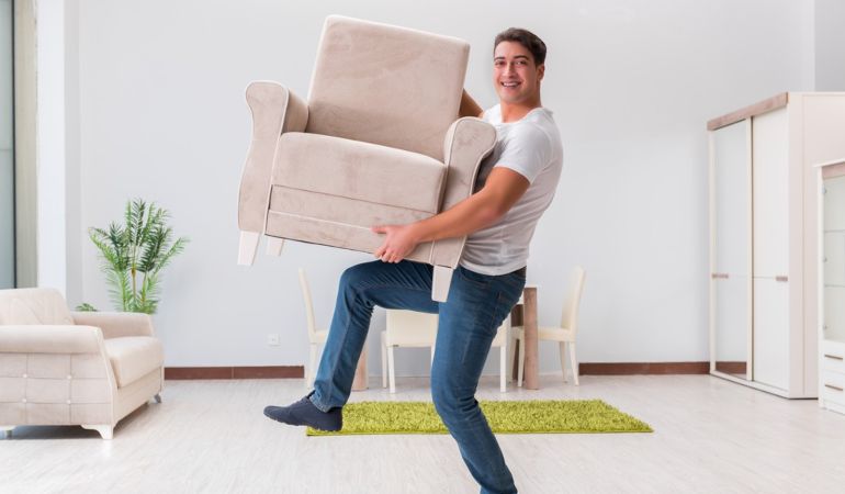 Man arranging furniture in his new home after a house move