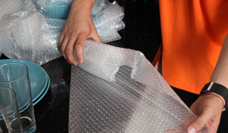 Using bubble wrap to pack glass for moving house