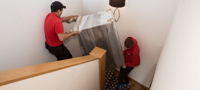Team moving a fridge down a flight of stairs