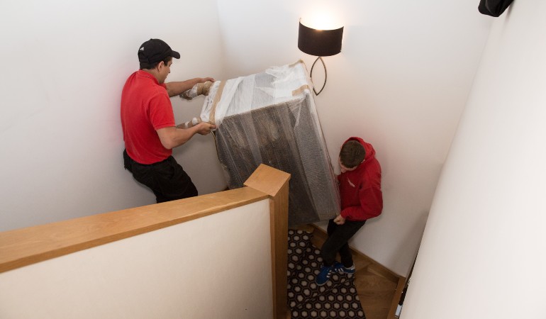 Team moving a fridge down a flight of stairs