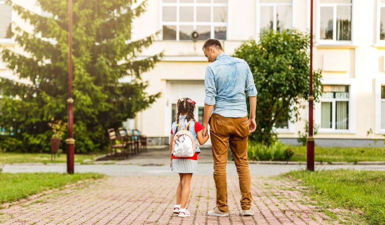 Father taking his child to her first day in a new school