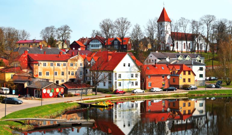 Colorful old town houses and church with lake reflection in spring morning in Talsi Latvia