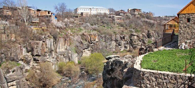 Rocky high canyon of Kasagh River in center of Ashtarak, town in Aragatsotn Province of Armenia, northwest of Yerevan. Small wooden pedestrian brigde across river.