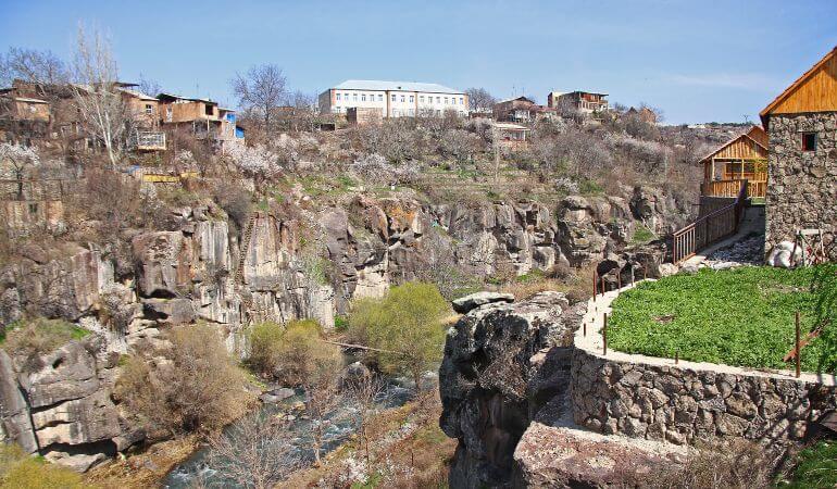 Rocky high canyon of Kasagh River in center of Ashtarak, town in Aragatsotn Province of Armenia, northwest of Yerevan. Small wooden pedestrian brigde across river.