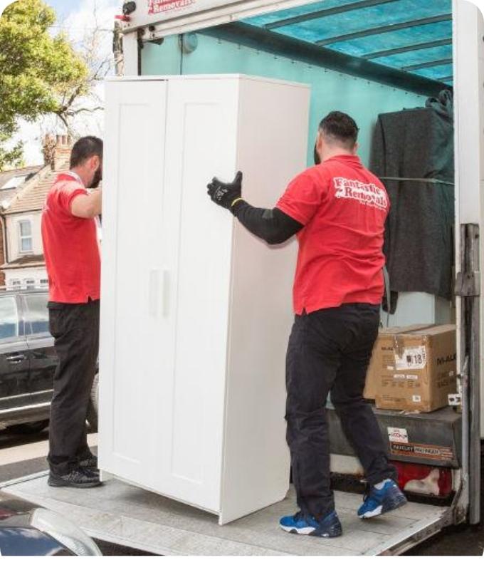 The image shows a two Fantastic Removals movers who are loading furniture to a van.
