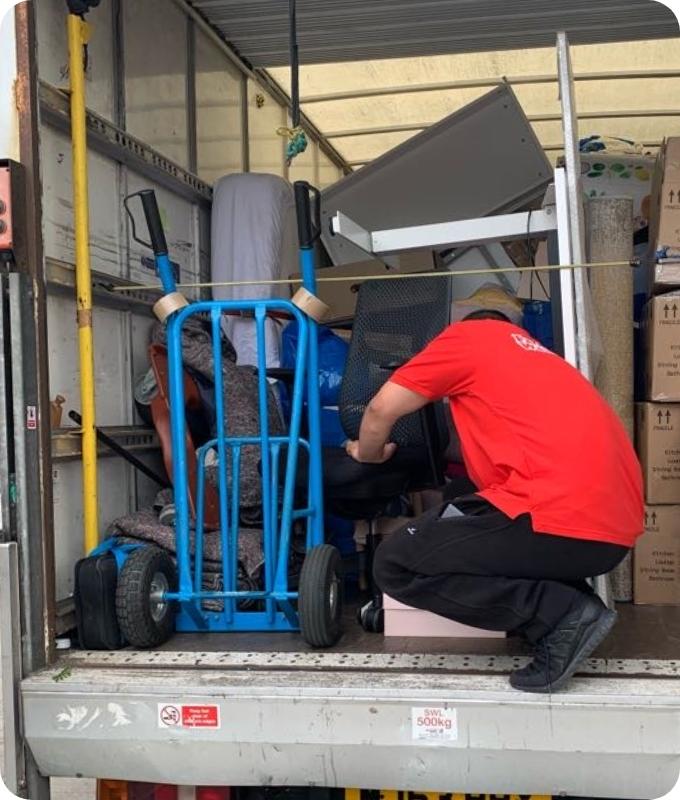 The image shows a mover who is loading a Fantastic Removals van with furniture and belongings during service.