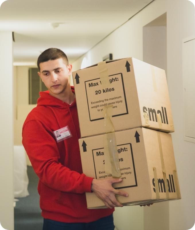 The image shows a Fantastic Removals mover who is working and carrying boxes with packed belongings.