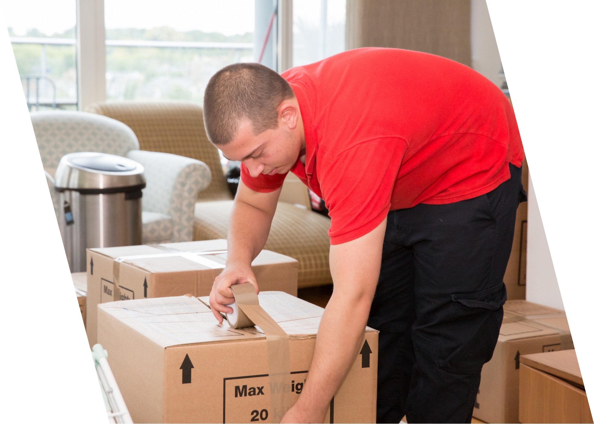 The image shows a Fantastic Removals specialist who is packing the belongings of a customer in a large box.